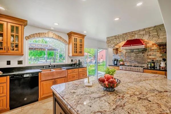 a kitchen with stainless steel appliances kitchen island granite countertop a stove a sink and a microwave