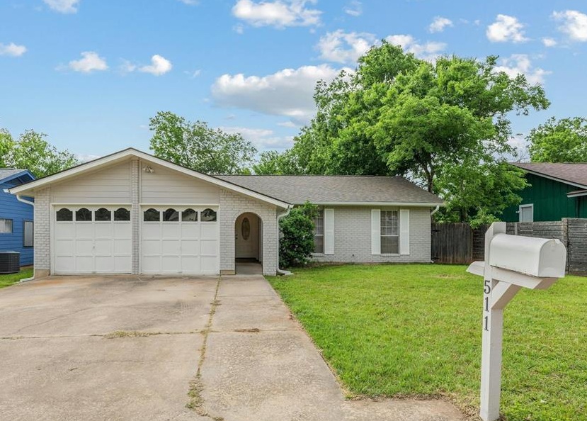 a view of a house with a yard and large tree