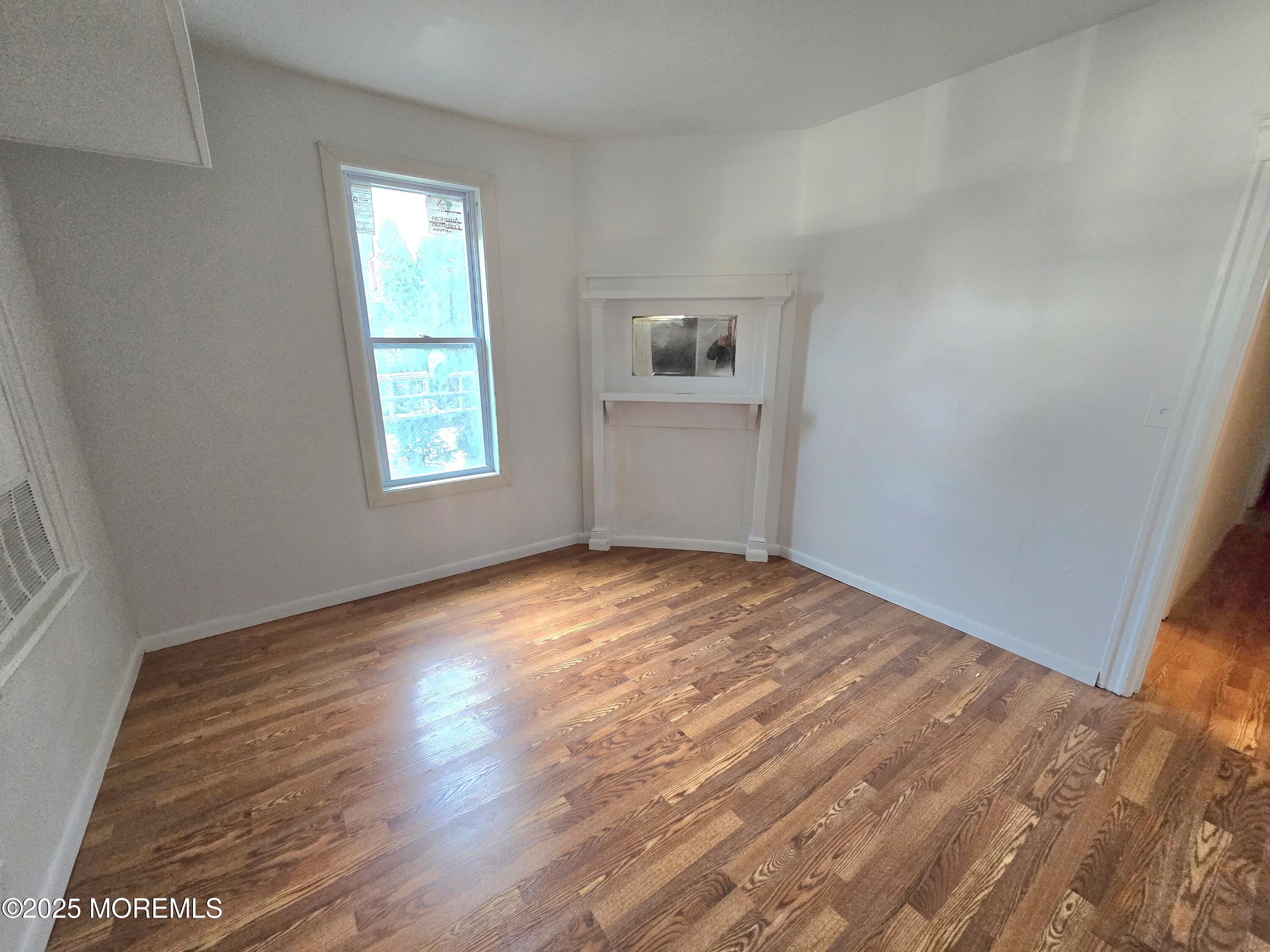 1010 Sewall Avenue, Unit 1 Asbury Park, NJ 07712 - Photo 1 of 6 a view of empty room with wooden floor and fan