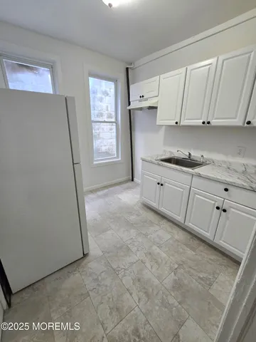 a kitchen with granite countertop white cabinets and white appliances