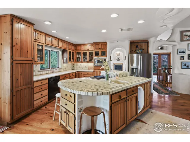 a view of kitchen island with stainless steel appliances granite countertop lots of wooden cabinets