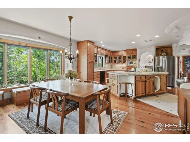 a open kitchen with stainless steel appliances kitchen island granite countertop a table chairs and a view of living room