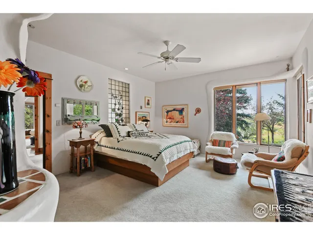 a spacious bedroom with a bed couch tv and window