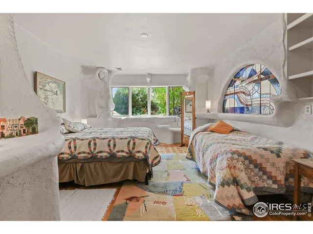 a bedroom with a bed a mirror and a window