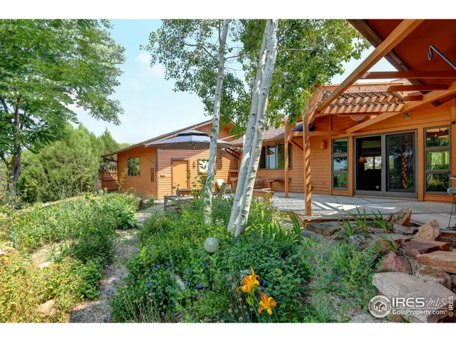 a view of a house with potted plants and a bench