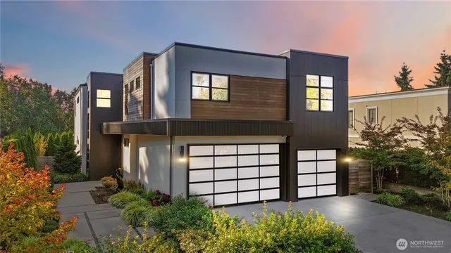 a view of a house with large windows and a flower garden