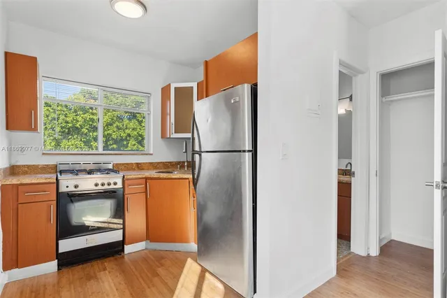 a kitchen with stainless steel appliances granite countertop a refrigerator and a stove