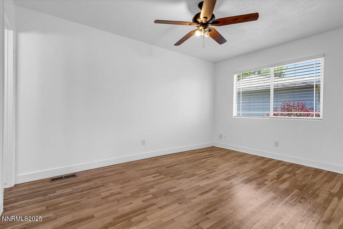 1340 Rayburn Drive Reno, NV 89503 - Photo 20 of 42 an empty room with wooden floor fan and windows