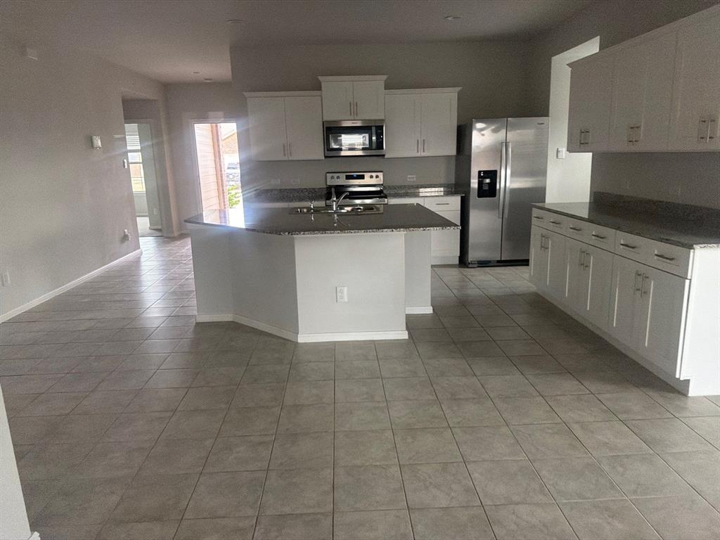 721 Durango Lane Cleburne, TX 76033 - Photo 25 of 25 a kitchen with stainless steel appliances granite countertop a stove a sink and a refrigerator
