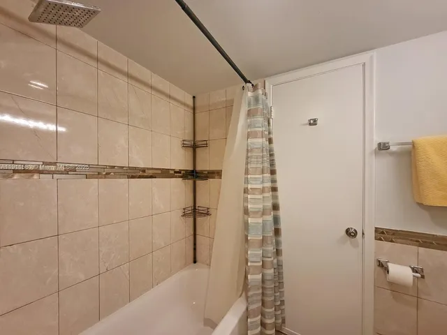 a bathroom with a shower and a bath tub