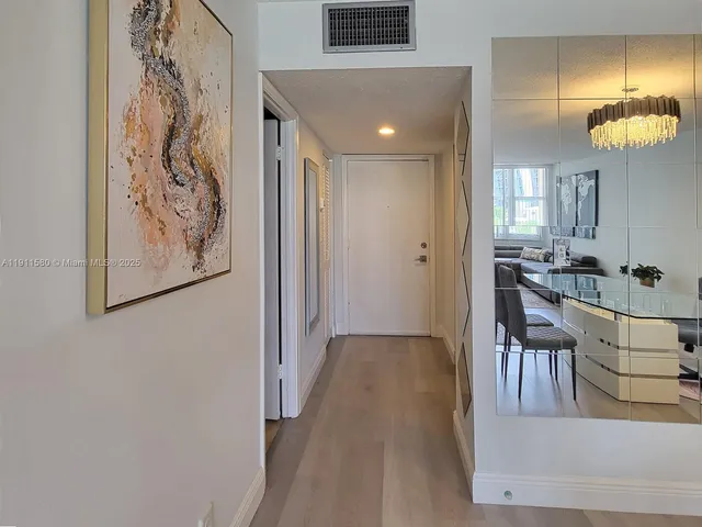 a view of a hallway to of a house with dining area