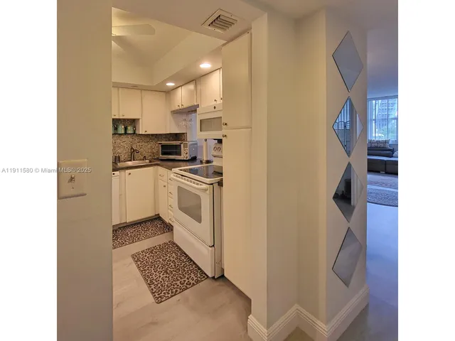 a kitchen with white cabinets and white appliances