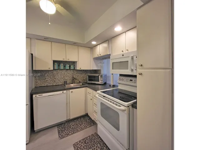 a kitchen with a sink a stove and cabinets