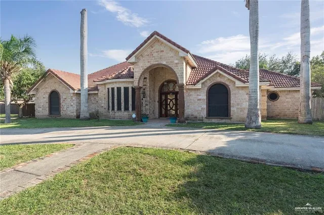 a front view of a house with a garden and plants