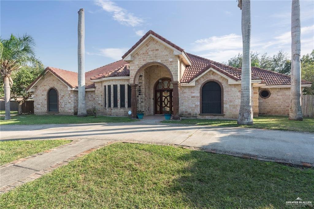 a front view of a house with a garden and plants