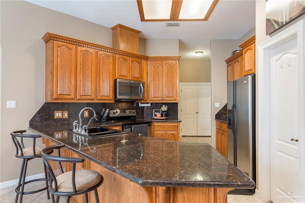 2802 South Pecan Boulevard Donna, TX 78537 - Photo 14 of 27 a kitchen with stainless steel appliances granite countertop a sink a stove and a refrigerator