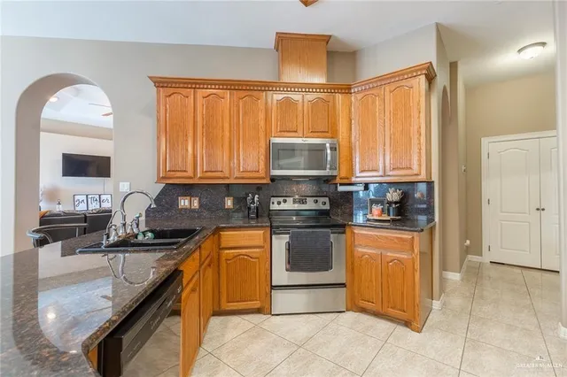 a kitchen with stainless steel appliances granite countertop a stove sink and cabinets