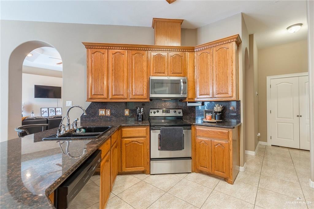 2802 South Pecan Boulevard Donna, TX 78537 - Photo 15 of 27 a kitchen with stainless steel appliances granite countertop a stove sink and cabinets