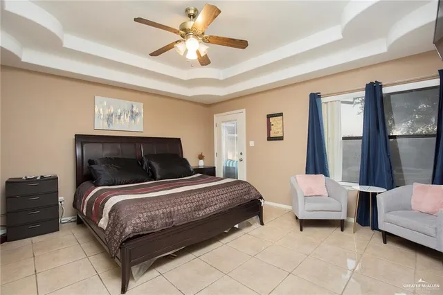 a bedroom with a bed couches and ceiling fan