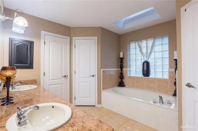 a bathroom with a tub sink and mirror