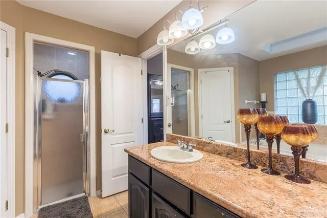 a bathroom with a granite countertop sink a mirror and a shower