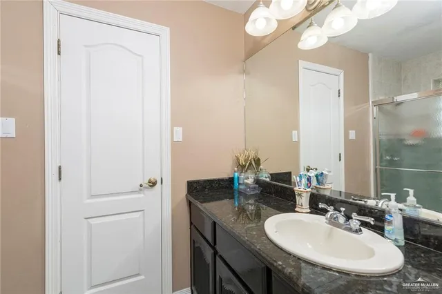 a bathroom with a granite countertop sink and a mirror