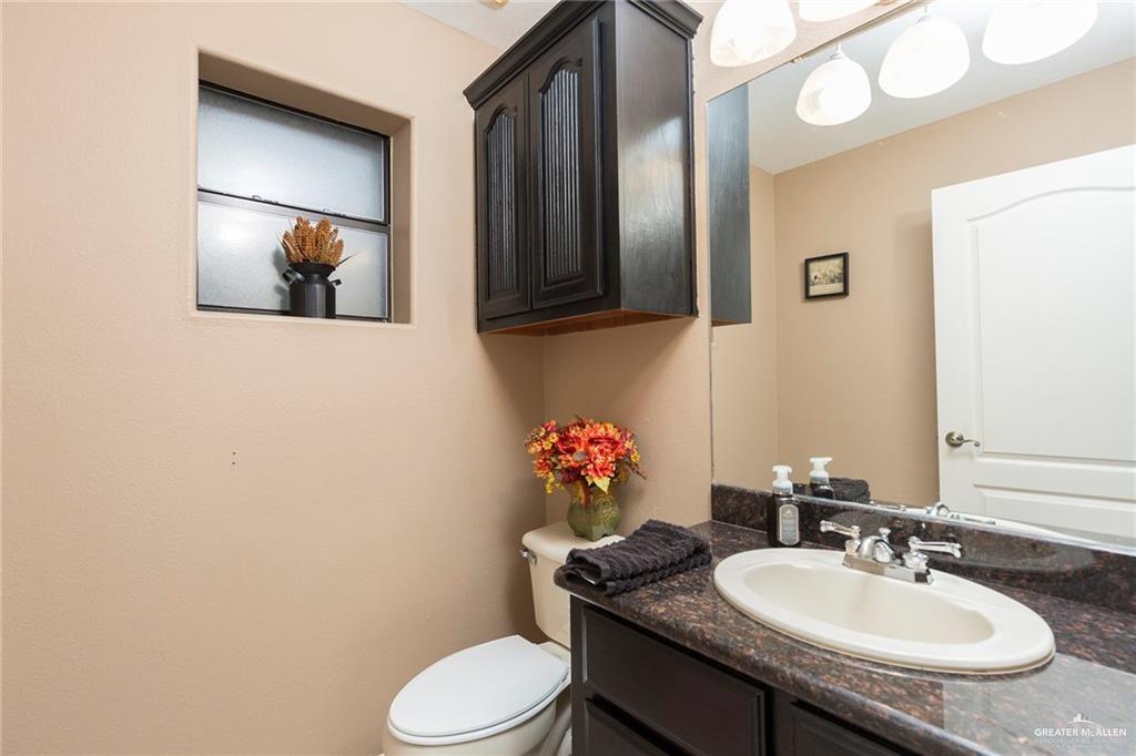 2802 South Pecan Boulevard Donna, TX 78537 - Photo 24 of 27 a bathroom with a granite countertop sink mirror vanity and toilet