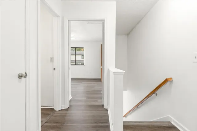 a view of a hallway with wooden floor and staircase