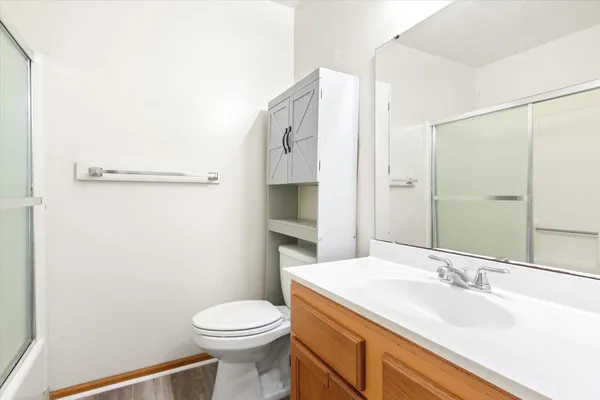 a bathroom with a sink a toilet and shower