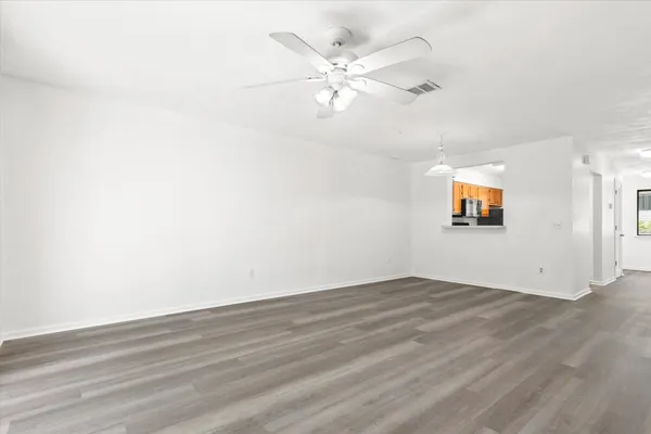 an empty room with wooden floor and windows