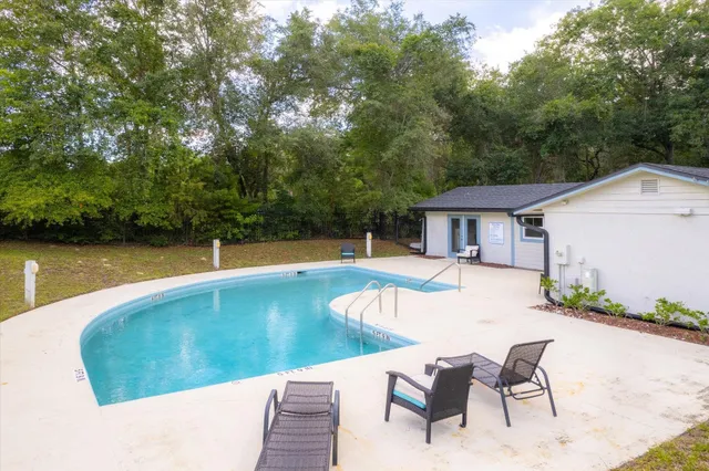 a view of a house with swimming pool and sitting area