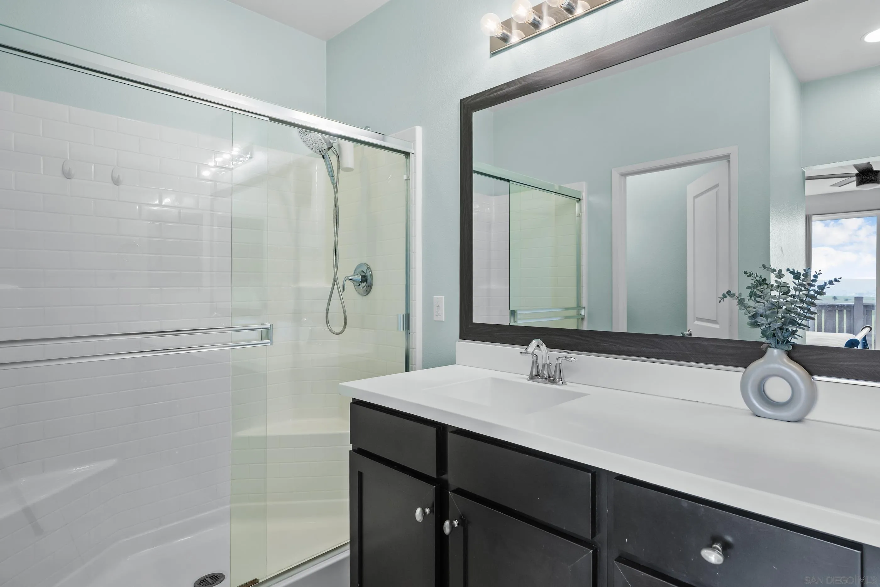 5481 San Roberto San Diego, CA 92154 - Photo 20 of 32 a bathroom with a shower sink and mirror