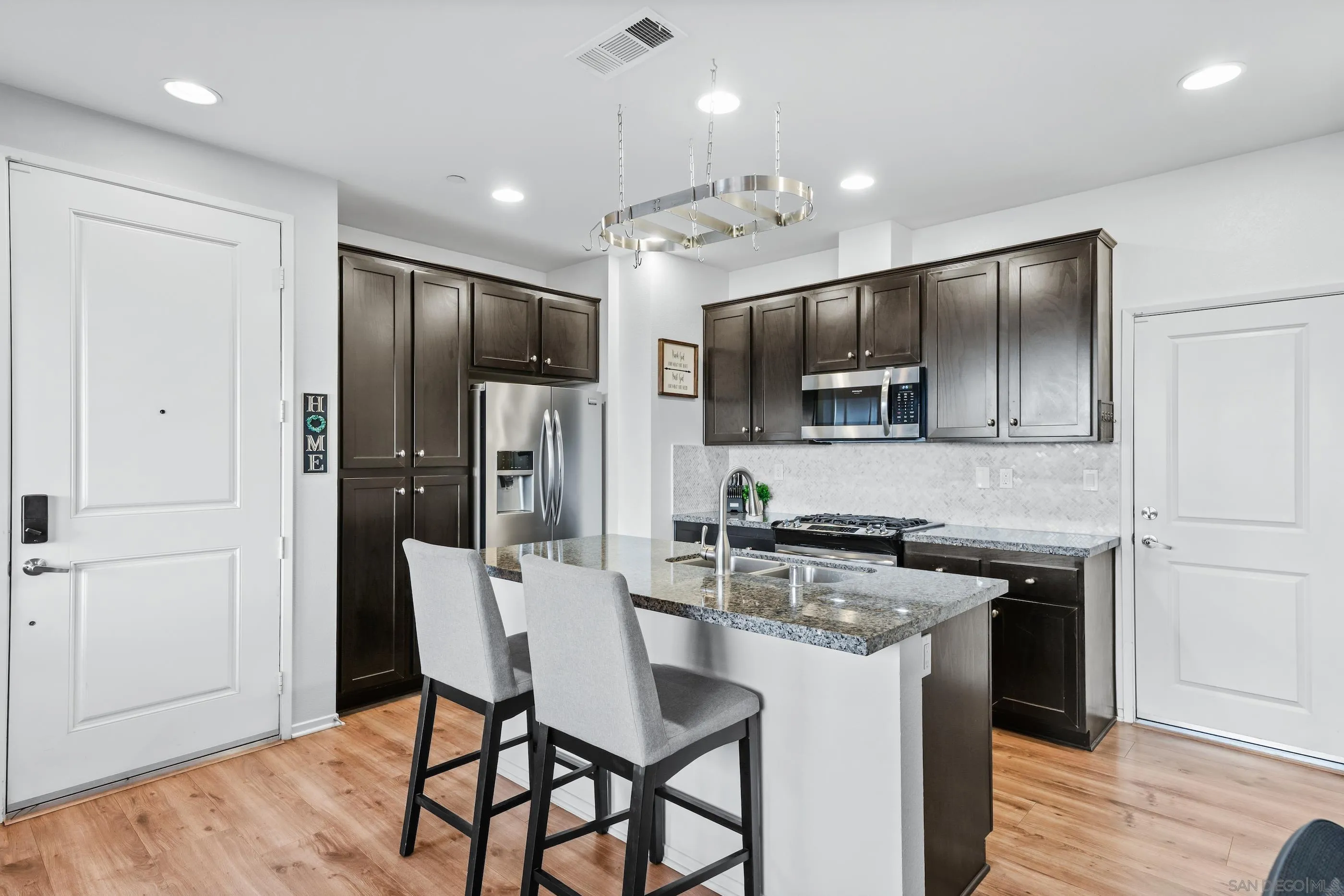 5481 San Roberto San Diego, CA 92154 - Photo 5 of 32 a kitchen with stainless steel appliances a kitchen island hardwood floor and a sink