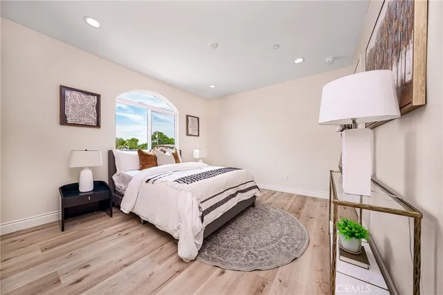 a bedroom with a bed and a potted plant on dresser