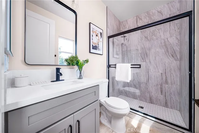 a bathroom with a sink a toilet and shower