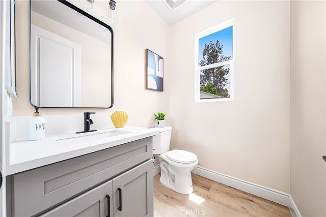 a bathroom with a granite countertop toilet sink and mirror