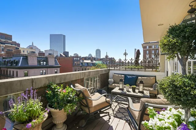 a view of a balcony with chairs and a potted plant
