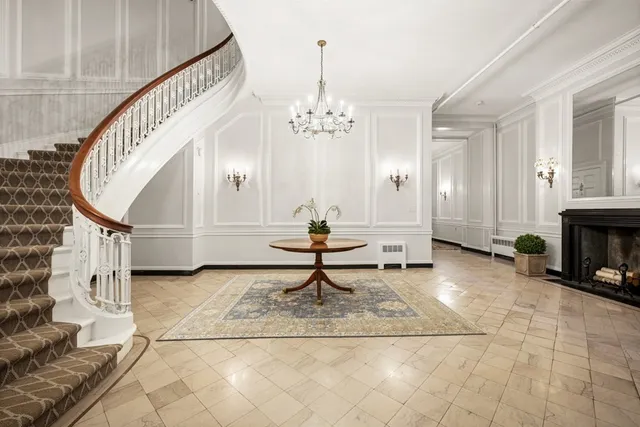 a living room with wooden floor and a chandelier