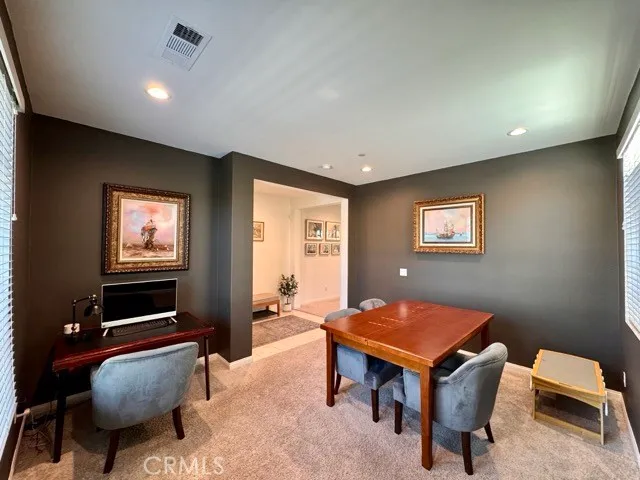 a kitchen with a dining table chairs and refrigerator