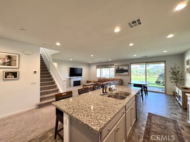 34110 Big Sur Drive Murrieta, CA 92563 - Photo 18 of 58 a view of a kitchen with kitchen island a stove a refrigerator a dining table and chairs with the wooden floor