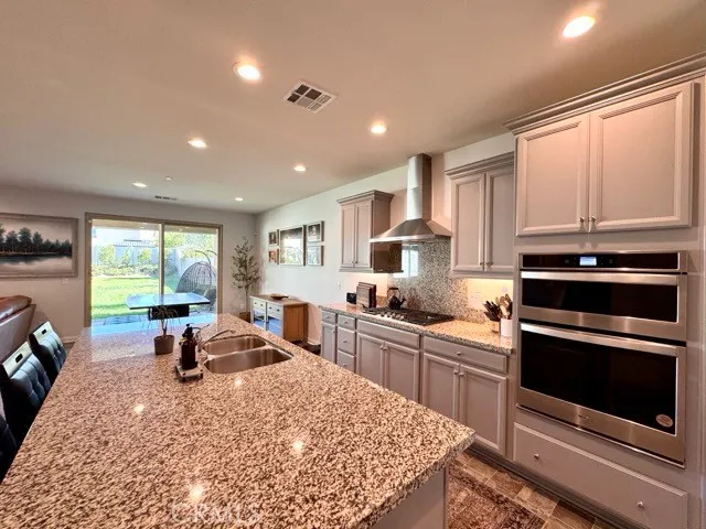 a living room with furniture a flat screen tv and kitchen view