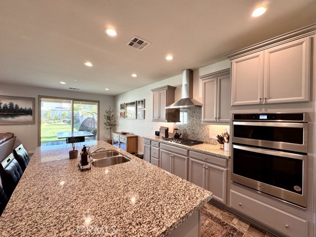 34110 Big Sur Drive Murrieta, CA 92563 - Photo 19 of 58 a kitchen with stainless steel appliances granite countertop a stove a sink dishwasher a microwave oven with cabinets and wooden floor