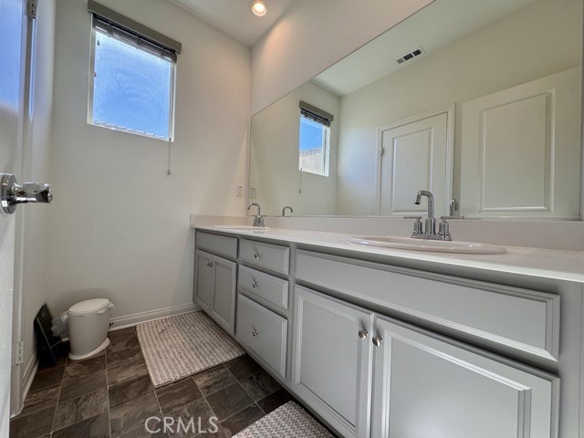34110 Big Sur Drive Murrieta, CA 92563 - Photo 45 of 58 a bathroom with a double vanity sink a mirror and a toilet