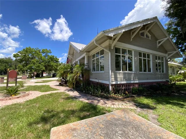 a view of a livingroom with furniture a fireplace and wooden floor