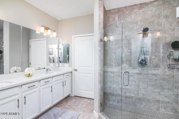 a bathroom with a double vanity sink mirror and shower