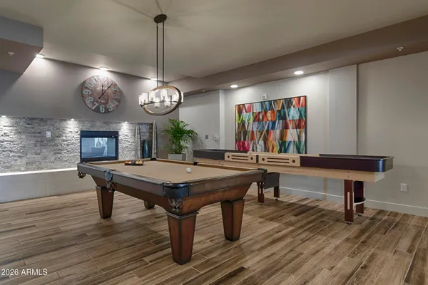 a room with furniture a clock potted plant and a chandelier