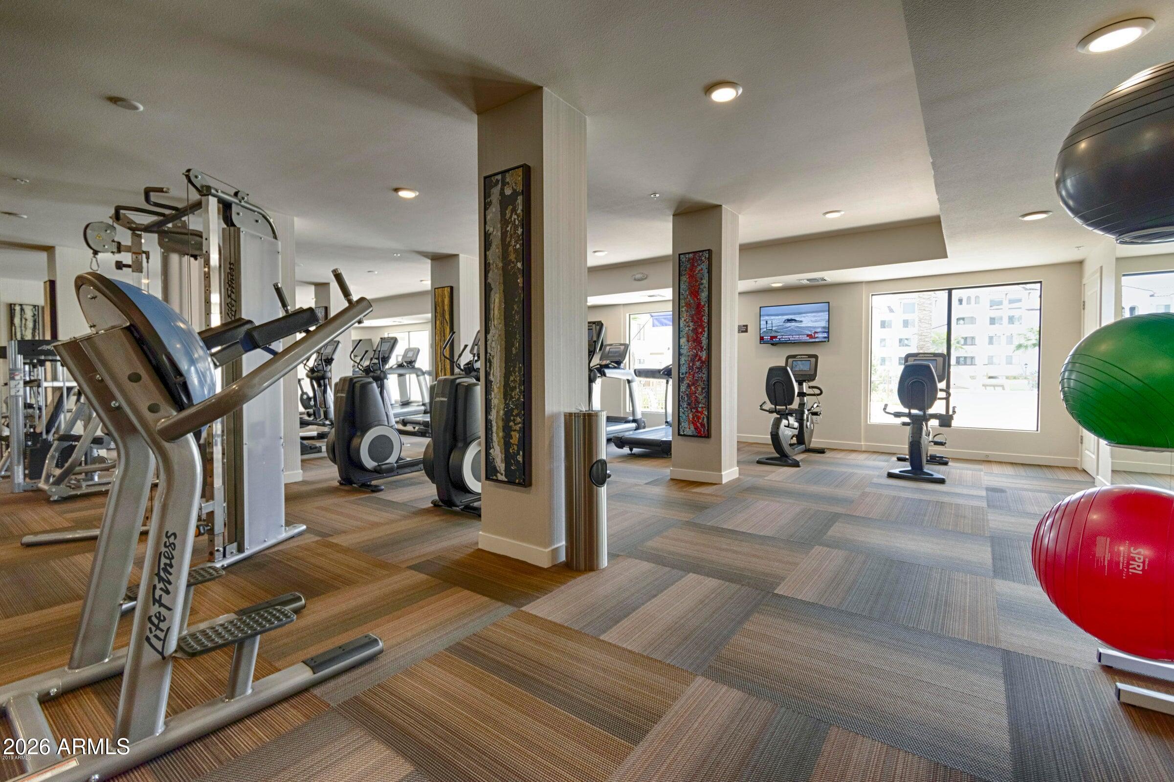 2511 West Queen Creek Road, Unit 260 Chandler, AZ 85248 - Photo 18 of 24 a view of a livingroom with furniture and a gym equipment