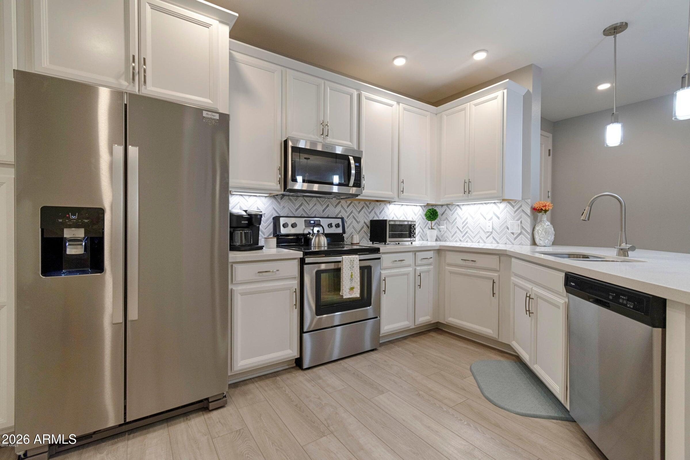 2511 West Queen Creek Road, Unit 260 Chandler, AZ 85248 - Photo 2 of 24 a kitchen with stainless steel appliances a refrigerator sink and microwave