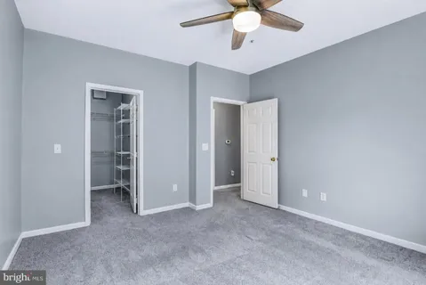 a view of an empty room with a chandelier fan