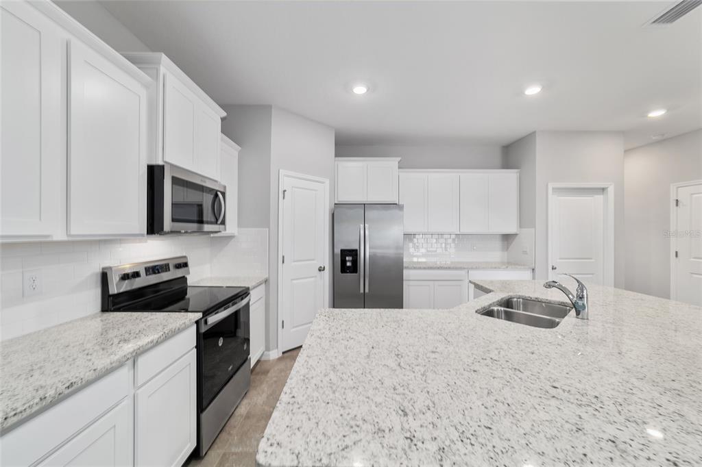 5339 Northwest 46th Ln Road Ocala, FL 34482 - Photo 18 of 79 a kitchen with granite countertop a sink and stainless steel appliances